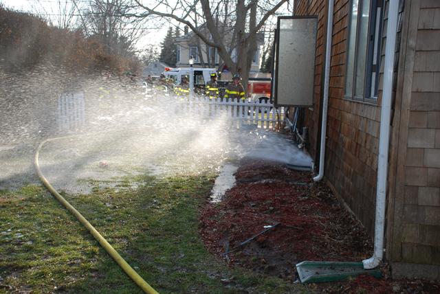 Gas fumes being vented from basement window using fog stream. 